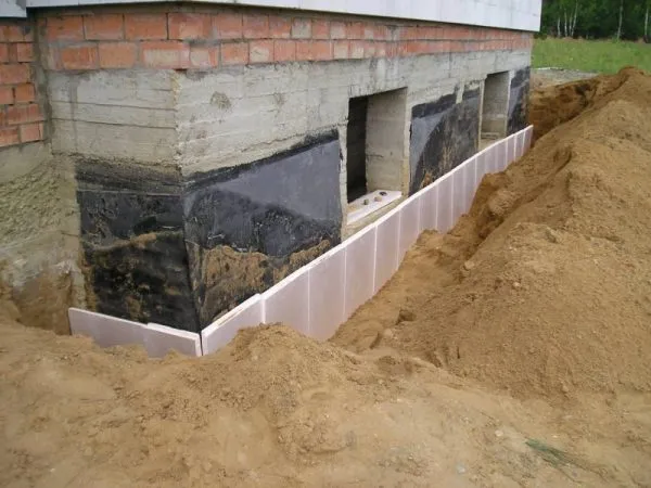Укладка листов пенопласта для изоляции цементных фундаментов
