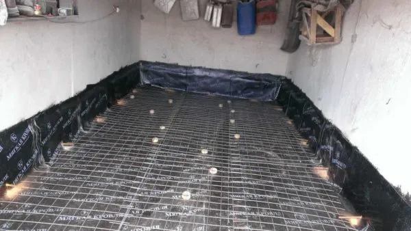Пол гаража герметизируется с помощью гидроизоляционной мембраны на полу и армирующей сетки, уложенной поверх кирпичей.